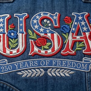 Puede incluir: Chaqueta vaquera azul con bordado "USA" en rojo, blanco y azul, adornada con motivos florales. La frase "250 YEARS OF FREEDOM" también está bordada en la prenda.