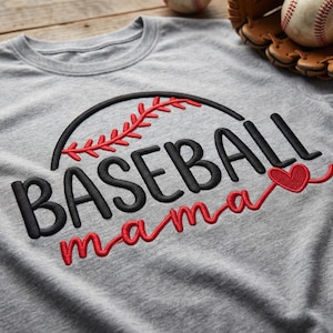May include: A gray t-shirt with the embroidered words "BASEBALL mama" in black and red thread. A baseball and glove are in the background. The design includes a baseball graphic and a heart.