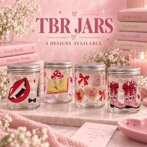 May include: Four clear glass jars with silver lids, each featuring distinct graphic designs including a vampire mouth, a mushroom on an open book, a heart-shaped locket with bows, and pink cowboy boots. The text TBR JARS 4 DESIGNS AVAILABLE is visible.