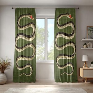 May include: A white ceramic mug with a black handle and the text "But First, Coffee" in a bold, black font. The mug is set against a blurred background, suggesting a cozy setting.