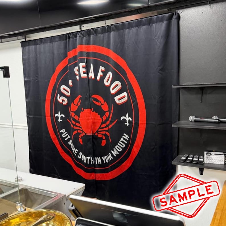 May include: Black curtain with a large red and white circular logo that says "50' Seafood" with a crab illustration. The text "PUT SOME SOUTH IN YOUR MOUTH" is also on the curtain. The word "SAMPLE" is stamped in red in the bottom right corner.