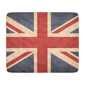 Pode incluir: Um tapete retangular com a Union Jack, a bandeira do Reino Unido. O design inclui elementos vermelhos, brancos e azuis com uma aparência desgastada e vintage. As bordas do tapete são arredondadas.