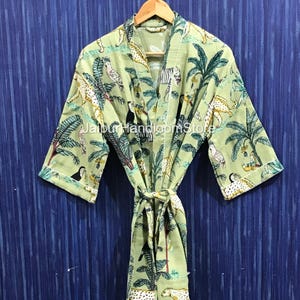 May include: A light green robe with a jungle-themed print featuring leopards, zebras, birds, and palm trees. The robe has a tie closure and is hanging on a wooden hanger. The text "Jaipur Handloom Store" is visible.