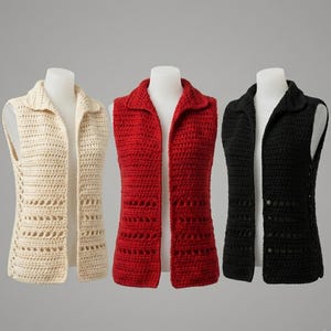Puede incluir: Tres chalecos de crochet abiertos en crema, rojo y negro. Cada chaleco tiene un cuello y un diseño sin mangas. El chaleco crema tiene un patrón calado decorativo en los laterales. Los chalecos se exhiben en maniquíes blancos.