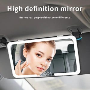 May include: A rectangular high-definition mirror with a white frame is attached to a car visor. The mirror reflects a woman's face. The text "High definition mirror" and "Restore real people without colour difference" are displayed above the mirror.