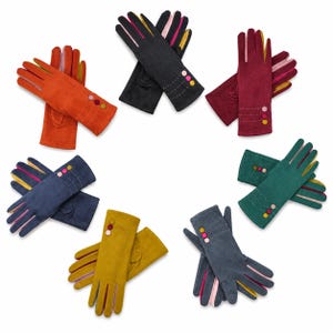 May include: A collection of seven pairs of suede-like gloves arranged in a circle. Each pair features a distinct solid colour, including orange, black, burgundy, green, mustard yellow, blue, and grey, with three small circular buttons and stitching.
