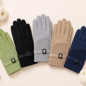 Könnte beinhalten: Fünf Paar Handschuhe in Grün, Schwarz, Grau, Beige und Marineblau. Jeder Handschuh verfügt über einen glatten oberen Bereich, ein strukturiertes Zopfstrickbündchen und einen dekorativen Riemen mit rechteckiger Schnalle am Handgelenk.