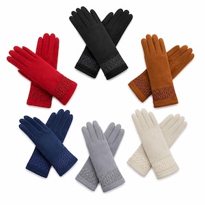 Può includere: Sei paia di guanti in rosso, nero, marrone, blu navy, grigio e beige. Ogni paio presenta una finitura morbida al tatto e un polsino decorativo con un motivo a rilievo che ricorda una spina di pesce. I guanti sono disposti in cerchio.