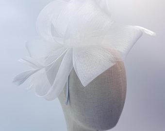 Nuevo tocado blanco con plumas, ideal para bodas en Royal Ascot y Kentucky Derby.