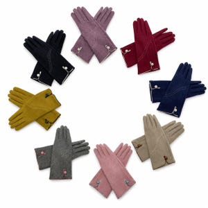May include: A collection of eight pairs of gloves arranged in a circle, featuring colours including black, purple, red, navy, beige, pink, grey, and mustard yellow. Each pair has a curved decorative stitch pattern and a small button at the wrist.