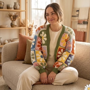 May include: A colorful, patchwork crochet cardigan with a floral design. The cardigan features squares of various colors, including blue, orange, yellow, and green, with white flower details. The sleeves and edges are trimmed in green.