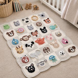May include: A cream-coloured, crocheted baby blanket with a patchwork design. Each square features a different animal face, such as a bear, monkey, and elephant. The blanket has a scalloped edge and is suitable for a nursery.