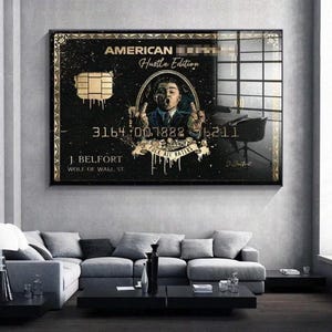 Puede incluir: Un cuadro rectangular con un diseño de tarjeta de crédito en negro y dorado. El texto dice AMERICAN, Hustle Edition, 3164 007888 6211, J. BELFORT, WOLF OF WALL ST. Una ilustración central muestra a un hombre con traje haciendo una peineta.