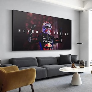 May include: A rectangular wall art print featuring a Formula 1 driver in a dark blue and red racing suit and helmet, arms raised in celebration. The text NEVER SETTLE is printed in white capital letters across the center of the dark background.