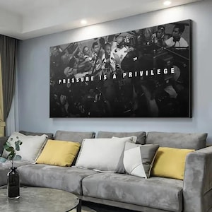 Op de afbeelding: Een rechthoekige zwart-wit wandkunstprint met een menigte mensen met camera's en microfoons rondom een centrale figuur, met de witte tekst PRESSURE IS A PRIVILEGE gecentreerd in het midden van de compositie.