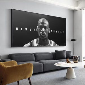 May include: A rectangular black and white wall art print featuring a portrait of Michael Jordan. The text NEVER SETTLE is printed in white capital letters across the center. The image shows the subject from the chest up in a jersey.