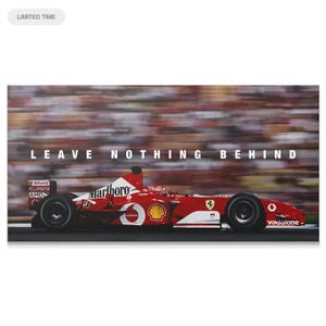 May include: A red Formula One race car speeding on a track with a blurred crowd in the background. The car features white logos including Marlboro, Shell, AMD, and Vodafone. The text LEAVE NOTHING BEHIND is printed in white above the race car.