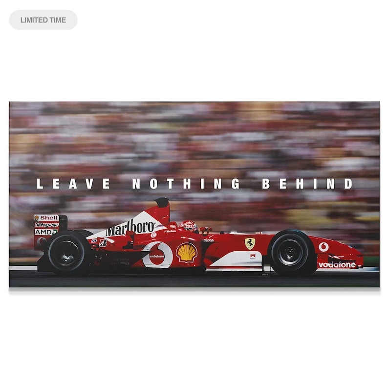 May include: A red Formula One race car speeding on a track with a blurred crowd in the background. The car features white logos including Marlboro, Shell, AMD, and Vodafone. The text LEAVE NOTHING BEHIND is printed in white above the race car.