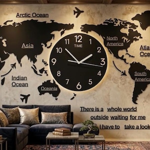 Può includere: Decorazione murale a mappa del mondo nera con un grande orologio rotondo al centro. L'orologio ha lancette bianche e una luce brillante attorno ai numeri. Il testo "There is a whole world outside waiting for me, I have to take a look" è sotto.