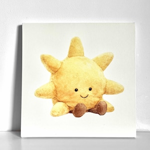 Pode incluir: Um brinquedo de sol amarelo de pelúcia com um rosto sorridente e pés castanhos. O sol tem oito raios e está sentado. O brinquedo é feito de material macio, provavelmente para crianças.