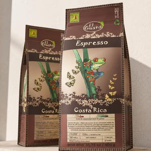 May include: Two brown coffee bags with the text "Espresso" and "Costa Rica". The bags feature a colorful illustration of a tree frog and butterflies. The bags are labeled "Women Owned" and the net weight is 900 g.
