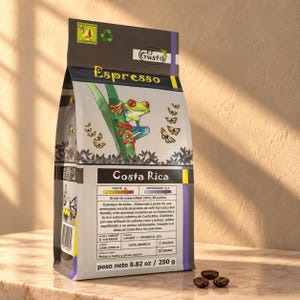 Op de afbeelding: Een zak van 250g El Gusto Espresso koffie uit Costa Rica. De verpakking bevat een illustratie van een roodoogmakikikker, vlinders en tekst met details over de herkomst, de branding en de smaaktonen van mout en pure cacao.