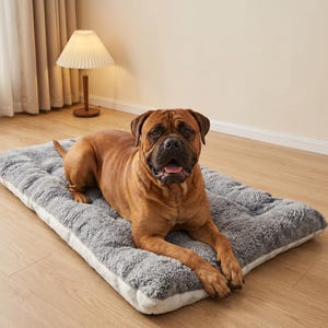 Peut inclure: Un grand chien brun est allongé sur un lit pour animaux de compagnie rectangulaire gris et blanc. Le lit a une surface en peluche texturée et un design matelassé. Le chien regarde directement la caméra.