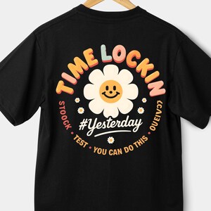 Könnte beinhalten: Schwarzes T-Shirt mit einem kreisförmigen Aufdruck auf dem Rücken. Der Aufdruck zeigt eine lächelnde Gänseblümchen-Blume und die Worte "TIME LOCKIN". Darunter stehen "#Yesterday" und "YOU CAN DO THIS".