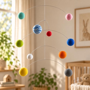 May include: A hanging mobile featuring multiple spheres in various colours including teal, pink, blue and white marbled, red, lime green, blue, white, orange, yellow, and grey, all suspended from thin silver metal wires in a tiered structure.