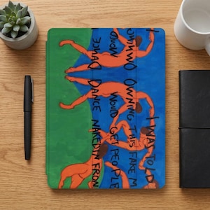 Puede incluir: Una funda para iPad con una ilustración colorida. El diseño presenta figuras naranjas en varias poses sobre fondos azules y verdes, con texto escrito a mano que dice "I WAS TOLD OWNING THIS FAKE M WOULD GET PEOPLE DANCE NAKED IN FRON".