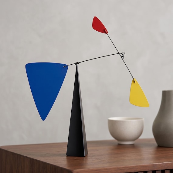 A Mondrian-inspired hand-fabricated steel kinetic sculpture with primary-color vanes — serious gallery-level kinetic art at a price that signals it.