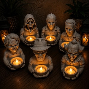 Könnte beinhalten: Eine Sammlung von sechs grauen, steinartigen Harzfiguren, die jeweils eine Horrorfilmfigur darstellen, die eine kleine Schale mit einem leuchtenden LED-Teelicht hält. Die Figuren zeigen unter anderem einen maskierten Geist und einen Clown.