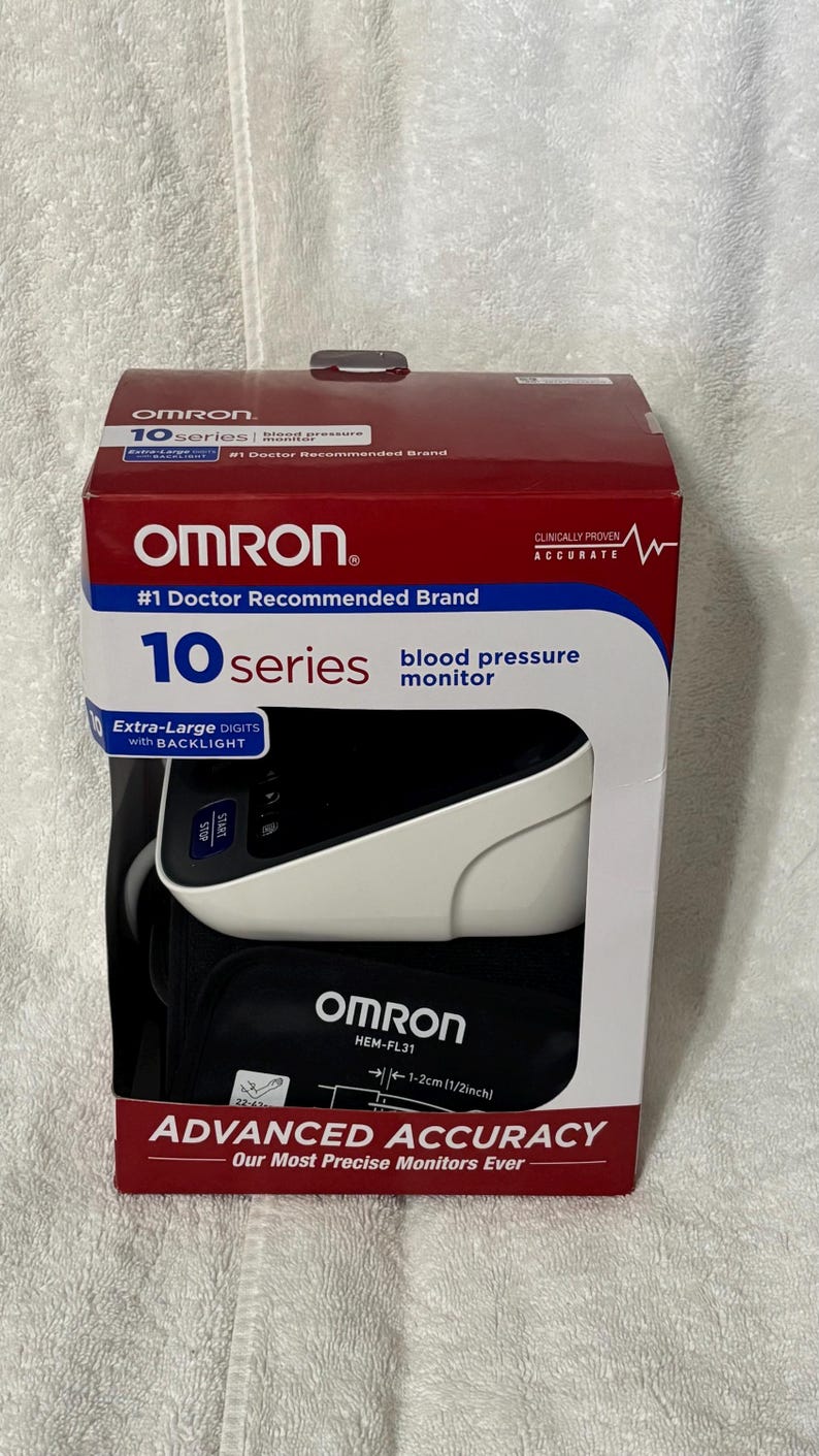 May include: An Omron 10 Series blood pressure monitor in its original red and white packaging. The box features the text #1 Doctor Recommended Brand, Advanced Accuracy, and shows the device with a black cuff and white monitor unit with a screen.