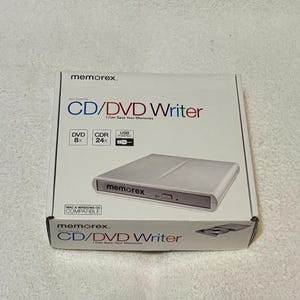 Puede incluir: Caja blanca de un grabador de CD/DVD Memorex. La caja tiene texto azul y rojo. El grabador de CD/DVD es plateado y tiene el logotipo de Memorex. También está el texto "I Can Save Your Memories".