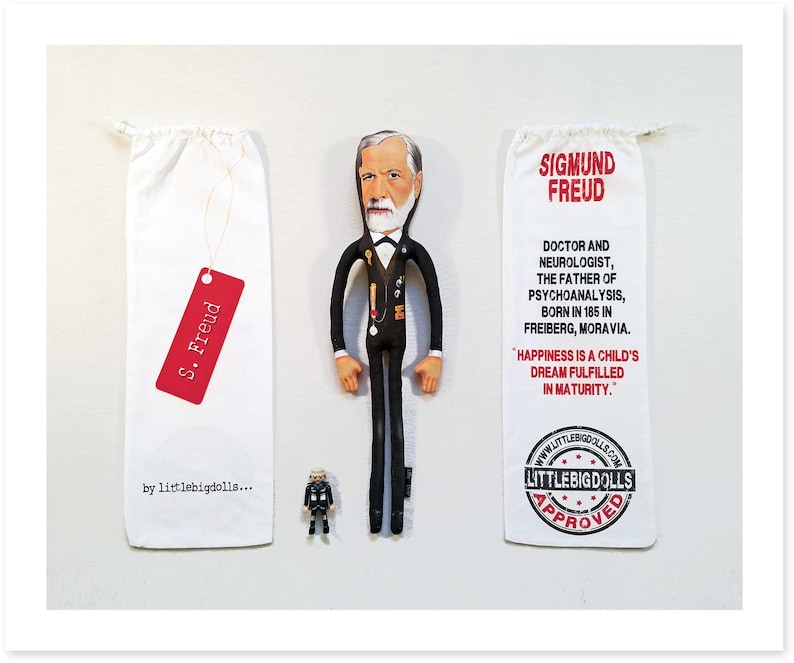 May include: A fabric doll of Sigmund Freud in a black suit, white shirt, and bow tie, with a miniature figurine and two white drawstring bags. One bag has a red tag that reads "S. Freud". The other bag has text about Freud.