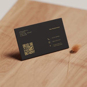Luxuriöse Visitenkarten Vorlage in Schwarz & Gold mit QR-Code, Kontaktdaten und goldenen Designelementen als individuell anpassbare Canva-Vorlage – Louvion.de