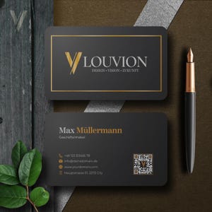 Könnte beinhalten: Zwei Visitenkarten und ein Stift. Die obere Karte zeigt den Text "VLOUVION DESIGN VISION ZUKUNFT" in Gold und Weiß auf schwarzem Hintergrund. Die untere Karte enthält den Namen "Max Müllermann" und Kontaktinformationen. Der Stift ist schwarz und goldfarben.