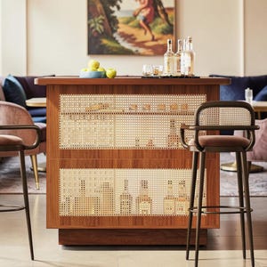 May include: A mid-century modern bar with a wooden frame and woven cane panels. The bar features a countertop with bottles, glasses, and a bowl of green apples. Two bar stools with brown metal frames and pink seats are in front of the bar.