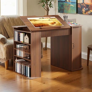May include: A wooden artist's desk with a slanted top, a built-in bookshelf, and a small cabinet. The desk is a warm brown color and has a painting on the top. The desk is 48 inches wide, 24 inches deep, and 36 inches high.