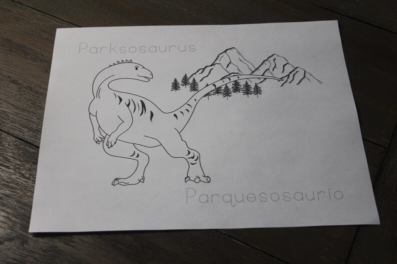 Puede incluir: Ilustraci&oacute;n en blanco y negro de un dinosaurio etiquetado como "Parksosaurus" con un fondo de monta&ntilde;as y &aacute;rboles. Tambi&eacute;n se incluye la traducci&oacute;n al espa&ntilde;ol "Parquesosaurio". El dibujo est&aacute; sobre una hoja de papel blanca.