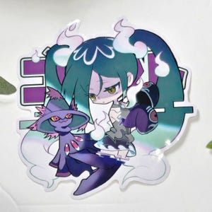 May include: A sticker featuring a stylized anime-style illustration of a girl and a purple creature. The girl has teal hair and a stern expression. The creature is purple with a witch hat. The background has Japanese text.