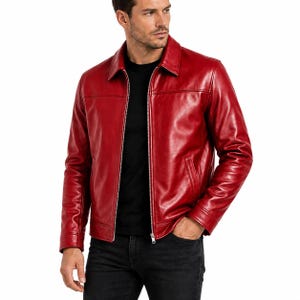 Könnte beinhalten: Eine leuchtend rote Lederjacke mit klassischem Kragen, durchgehendem silberfarbenem Frontreißverschluss, langen Ärmeln mit geknöpften Manschetten und zwei schrägen Seitentaschen. Die Jacke hat eine glatte Oberfläche und horizontale Nahtdetails.