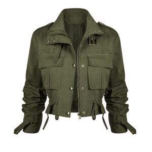 May include: An olive green cropped utility jacket featuring a high collar, a front zipper closure, and multiple flap pockets. The jacket includes shoulder epaulets, adjustable cuffs with straps, and a drawstring waist with hanging cord ends.