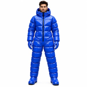 May include: A bright blue, high-gloss, full-body puffer jumpsuit featuring a quilted design, a hood, and a central black zip closure. The garment includes matching blue gloves and integrated boots, creating a uniform, insulated appearance.