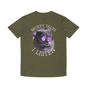 May include: An olive green t-shirt with a cat wearing purple sunglasses. The text "MONEY TALKS I LISTEN" is printed above and below the cat image in white. A casual wear item.
