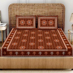 May include: A brown bed set with a repeating sun and tree pattern. The set includes a fitted sheet, two pillowcases, and a matching patterned border. The bed is made up with a woven headboard.