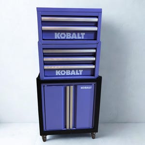 Könnte beinhalten: Ein violetter Werkzeugschrank aus Metall mit mehreren Schubladen und einem unteren Schrankfach. Das Gerät verfügt über silberfarbene Schubladengriffe und den Markennamen KOBALT, der in Weiß auf den Schubladenfronten und der Schranktür steht.