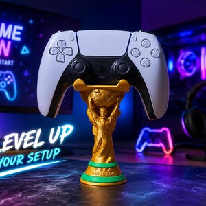 May include: A white and black video game controller resting on a gold-colored trophy-shaped stand. The stand features a figure holding a globe above its head, with a green base displaying the text FIFA WORLD CUP in raised gold lettering.
