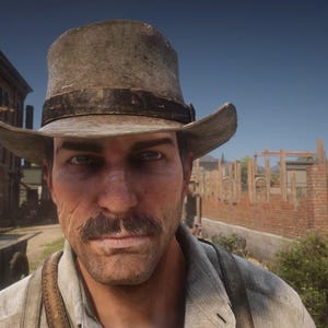 May include: A close-up shot of a man wearing a weathered, light brown hat with a dark band. He has a mustache and is looking directly at the camera. The background shows a building and a street, suggesting a Western theme.