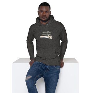 May include: Dark grey hoodie with a drawstring hood and a front pocket. The hoodie features the text "Clean Run, Clear Heart" with a graphic of a running shoe. The person in the image is wearing blue jeans.